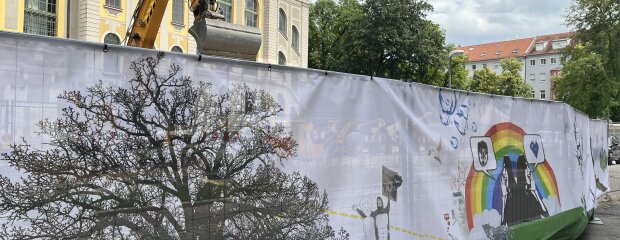 Das Bauzaunbanner an der Staats- und Stadtbibliothek strahlt in bunten Farben.